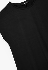 Mustaa lyhythihainen tunika, jossa on pyöreä pääntie, valmistettu sileästä ja kevyestä kankaasta. Tunikassa on puhtaat linjat ja rento istuvuus.