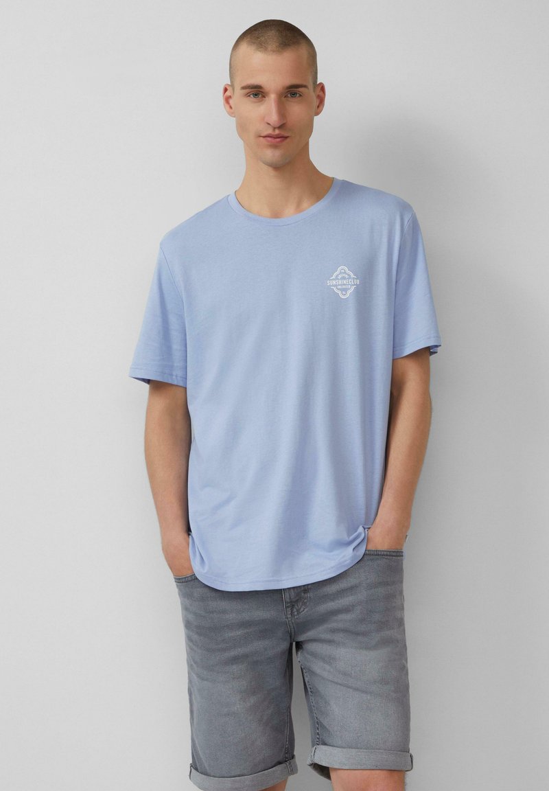 Lichtblauwe katoen t-shirt met een ronde hals en korte mouwen, met een klein wit logo bedrukt op de linkerborst.