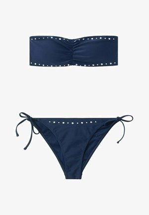 Bikini azul marino sin tirantes con tachuelas plateadas a lo largo de los bordes superiores del bandeau y de la braguita con lazos laterales.