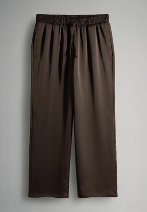 Ruskeat, kevyet satiinihousut, joissa on joustava vyötärö ja säädettävä nauha. Housuissa on leveä lahje ja sileä pinta.