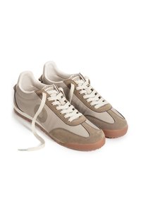 Paire de baskets décontractées beige et marron à lacets blancs avec semelles en caoutchouc, vues en perspective frontale inclinée.