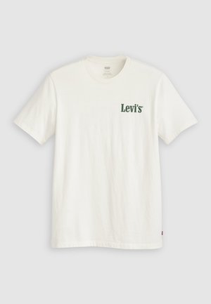 Maglietta bianca a maniche corte con logo "Levi's" verde sul petto a sinistra e una piccola etichetta rossa Levi's sul lato inferiore destro.