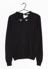 Czarny sweter z długim rękawem i kołnierzykiem. Posiada dekoracyjne kryształowe akcenty na kołnierzu. Miękka, teksturowana tkanina.