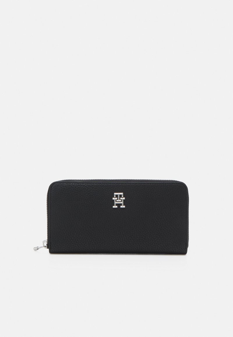 Black leather wallet with a textured finish, featuring a silver logo on the front and a zip closure along the top edge.
