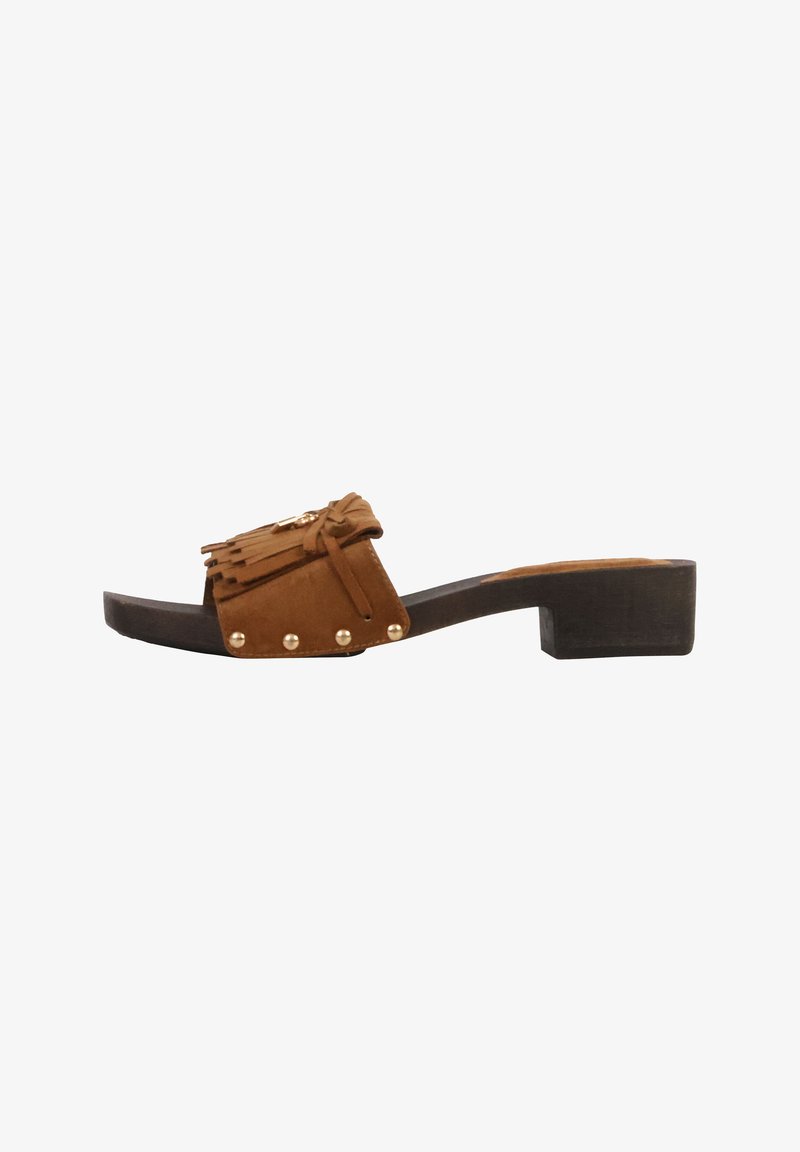 Sandale mule en daim marron avec petit talon bloc, franges et détails de clous dorés sur la lanière.
