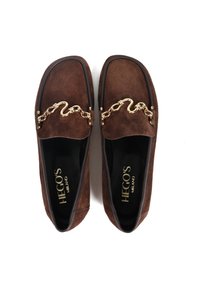 Brązowe zamszowe mokasyny z złotym łańcuchem na górze. Okrągły czubek i czarne wykończenie wewnętrzne. Gładka podeszwa.
