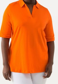 Klarr orange polo-shirt med v-ringning, korta ärmar och knappad krage, tillverkad av slät tyg, med en avslappnad passform.