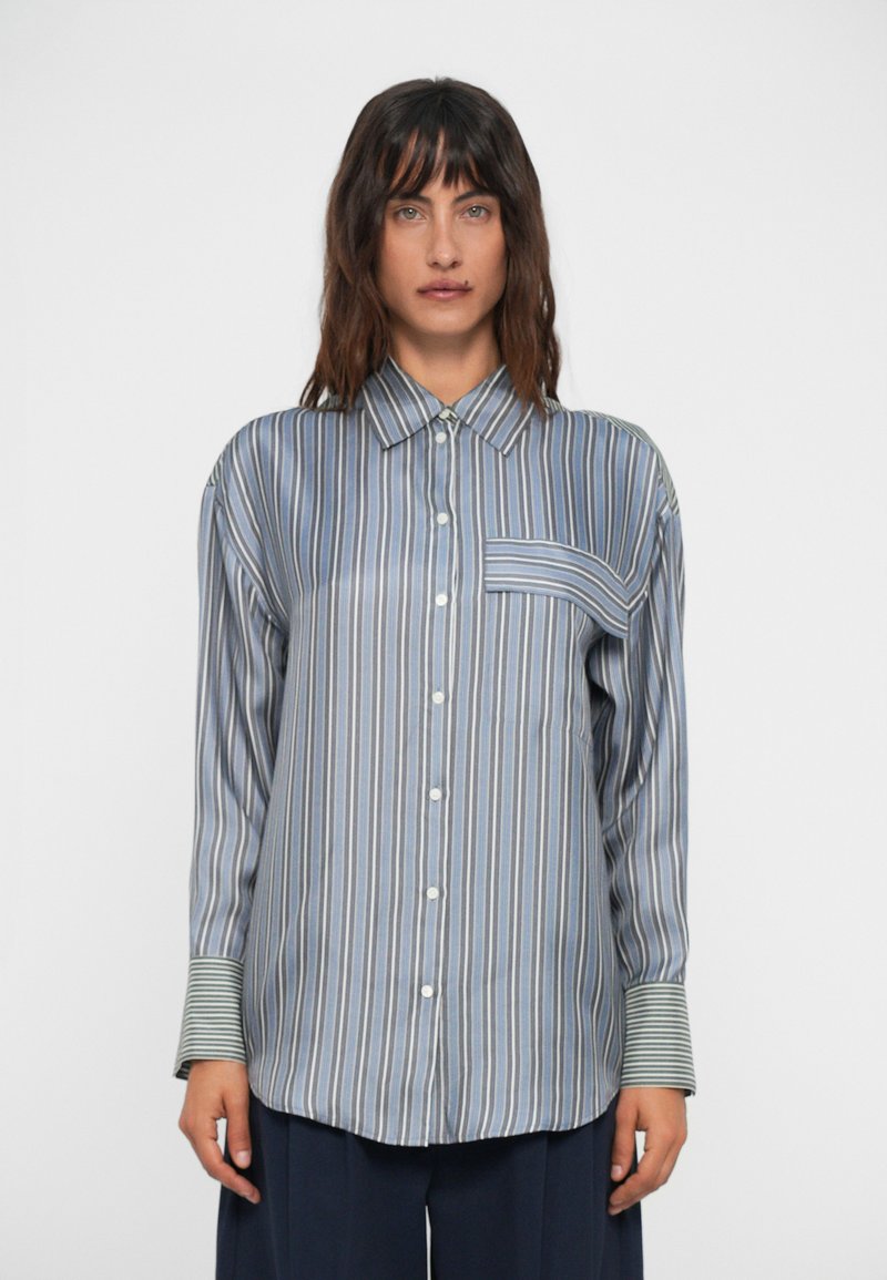 Striped button-up shirt in blue, white, and green with a pocket, long sleeves, a collared neckline, and contrasting striped cuffs.