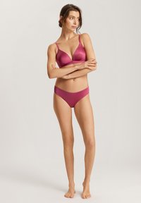 Set di lingerie fucsia composto da un reggiseno imbottito e liscio con coppe a triangolo e spalline regolabili, abbinato a un perizoma senza cuciture.