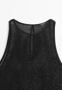 Černý top bez rukávů vyrobený z síťového materiálu s kulatým výstřihem, který má malé zapínání na knoflík na zadní straně a texturovaný vzor.