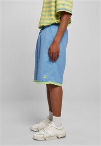 Gaiši zili šorti ar zaļu apdari, ar S logotipu. Izgatavoti no viegla materiāla, ar elastīgu jostu un sānu kabatām.