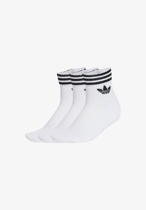 Calcetines tobilleros de algodón blanco con puños a rayas negras, que presentan un logo negro en un lado. El paquete incluye tres pares.