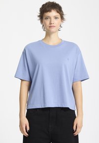 T-shirt di cotone azzurro chiaro con maniche corte, scollatura rotonda e vestibilità rilassata. Presenta un piccolo logo ricamato sul lato sinistro del petto.