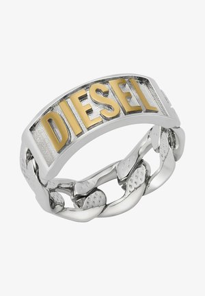 Anillo de metal plateado con un diseño curvado, que presenta un logo dorado de "DIESEL" en una banda texturizada. La banda se entrelaza con acentos en forma de cadena.