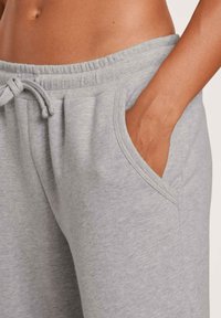 Grijze katoenen joggingbroek met een tailleband met trekkoord, zijzakken en een gestructureerd oppervlak. De tailleband heeft een geribbelde afwerking.