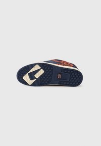 Sole of navy and orange skate shoe with patterned tread and "Globe Nitrocel" label on a plain background.