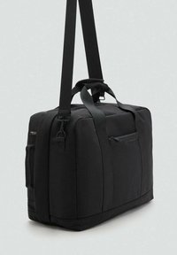 Sort duffel taske lavet af holdbart stof med to bærehåndtag og en justerbar skulderrem. Har en lynlåslomme foran.