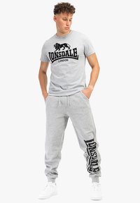 Gray cotton t-shirt with black logo "Lonsdale London" on the front; paired with matching gray joggers featuring logo print along the leg.