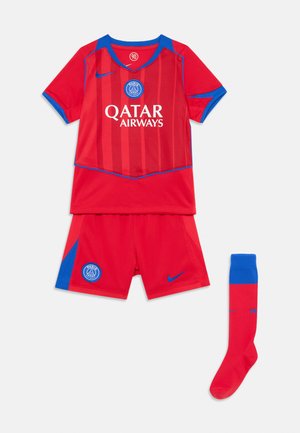 Tenue de football rouge comprenant un maillot avec des accents bleus, le logo "QATAR AIRWAYS", un short assorti et une chaussette rouge avec un haut bleu.