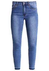 Modré džíny z denimu s úzkým střihem, které mají zapínání na knoflík, pět kapes a jemné blednutí podél nohavic.