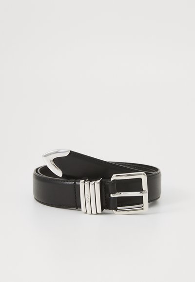 Cintura in pelle nera con una fibbia in metallo argentato lucido, caratterizzata da tre scanalature orizzontali vicino alla fibbia e una texture liscia e elegante.