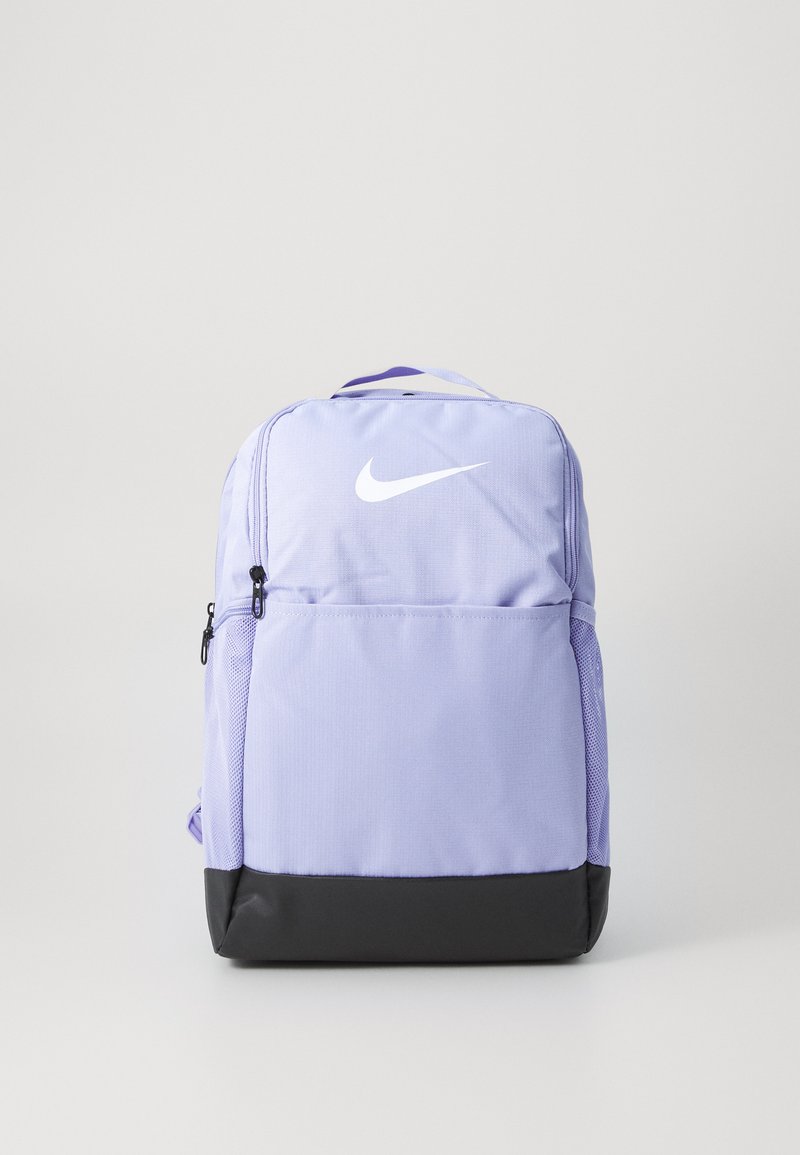 Sac à dos en tissu violet avec un bas noir, comportant un logo Nike blanc. Comprend une poche avant zippée et des poches latérales en mesh.