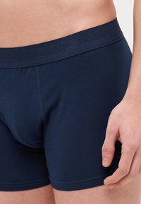 Mørkeblå bomullsboxershorts med myk elastisk linning, med en tettsittende design og minimale sømdetaljer.