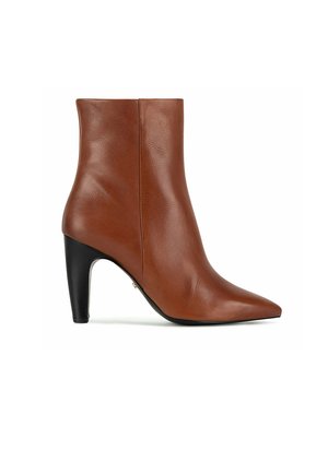 Hnědá kožená kotníková bota s špičatou špičkou a černým vysokým blokovým podpatkem, zobrazená z boku na bílém pozadí.
