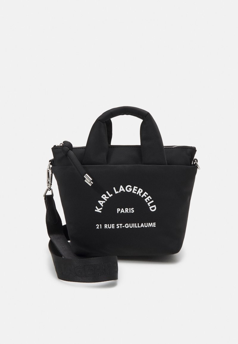 Sac à main noir Karl Lagerfeld avec deux poignées, une bandoulière amovible et un texte imprimé blanc sur le devant.