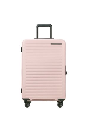 Pink hard-shell suitcase with vertical grooves, retractable black handle, and four spinning wheels for mobility. Zipper closure, compact design.