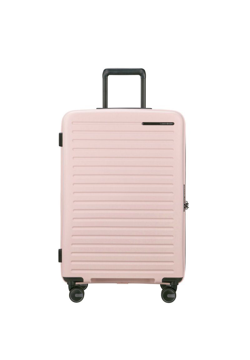 Pink hard-shell suitcase with vertical grooves, retractable black handle, and four spinning wheels for mobility. Zipper closure, compact design.