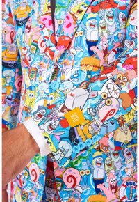 Colorful suit jacket featuring a cartoon character print on a light blue background. It has a white shirt cuff and light blue buttons.