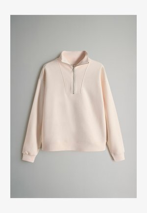 Light pink sweatshirt with a high collar, half-zip closure, and ribbed accents. Features long sleeves and a relaxed fit. Soft texture.