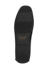 Suela de zapato de cuero negro con surcos horizontales y logo en dorado "WITTCHEN handmade" en relieve. Superficie texturizada para una mejor tracción.
