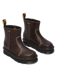 Bruine leren enkelboots met elastische zijpanelen, contrasterende witte stiksels en een gele trekriem op de bovenzijde. Dikke zwarte zool.