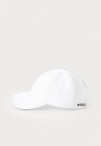 White baseball cap with a curved brim, made of breathable fabric featuring perforated details, and "BOSS" logo on the side.