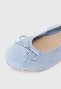 Ανοιχτό μπλε σουέτ μπαλαρίνες με στρογγυλή μύτη, με μικρή φιόγκο διακόσμηση και ραφές στο πάνω μέρος.