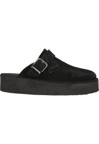 Svart mocka slip-on sko med ett brett band, metallspänne och en tjock, texturerad svart plattformssula för ökad höjd och komfort.