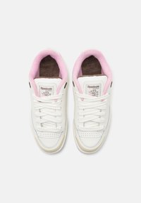 Sneaker bianche con accenti rosa, tomaia in pelle, design con lacci, punta rotonda e una morbida soletta marrone. Presenta il logo Reebok sulla linguetta.