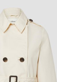 Beiger zweireihiger Trenchcoat mit weitem Kragen, dunklen Knöpfen, Schulterklappe und Taillengürtel von s.Oliver.