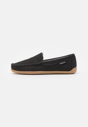 Sort Polo slip-on mokasin med flettet detalje og brun gummisål, sideetiket synlig, vist på hvid baggrund.