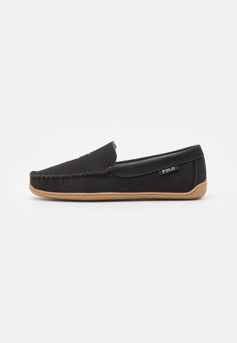 Mocasín tipo slip-on Polo negro con detalles trenzados y suela de goma marrón, etiqueta lateral visible, exhibido sobre fondo blanco.