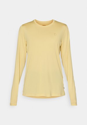 Langarmshirt in lichtgeel, gemaakt van zachte stof. Heeft een ronde halslijn en een subtiel logo-detail op de borst. Soepele textuur.