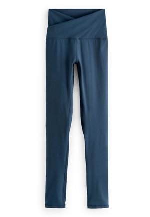 Marineblauwe leggings met hoge taille, een brede, overlappende tailleband, platte naden en pijpen in volledige lengte op een witte achtergrond.