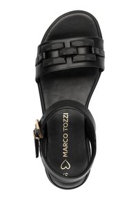 Schwarze Sandale mit zwei breiten Riemen, die ein dekoratives geometrisches Kettenmuster aufweist. Verstellbarer Knöchelriemen mit goldfarbener Hardware.