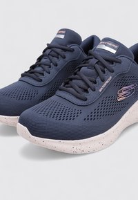 Zapatillas navy impermeables con una parte superior de malla texturizada, que presenta perforaciones para la transpirabilidad y una suela blanca moteada.
