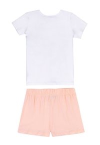 T-shirt bianco a maniche corte con scollo rotondo abbinato a pantaloni corti color pesca con vita elastica. Entrambi gli articoli hanno una texture liscia.