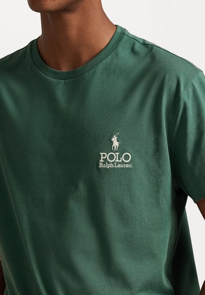 Green cotton t-shirt features a crew neck, short sleeves, and a white embroidered logo with a horse and text on the left chest.