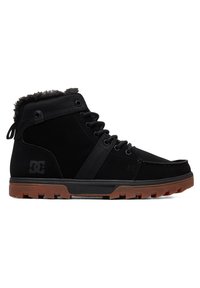 Black high-top shoes made of suede and fabric; features a fur-lined collar, rubber sole, and lacing system; DC logo on side.