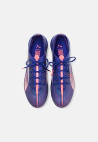 Scarpe sportive con un design viola e rosa, materiale superiore texture, lacci blu piatti e una striscia centrale rosa.